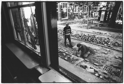 351561 Afbeelding van de stratenmakers G. van Arem en G. Nesselaar van de dienst Stadswerken tijdens het opnieuw ...